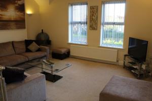 a living room with a couch and a tv at A Family Apartment in Sleights - 2D Lowdale Lane in Sleights