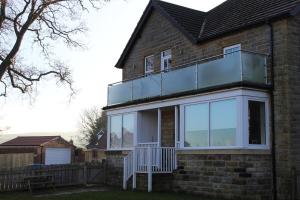 a house with a glass balcony on top of it at A Family Apartment in Sleights - 2D Lowdale Lane in Sleights