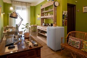 a living room with green walls and a table and a refrigerator at il Palchetto B&B di Charme e Design in Palermo