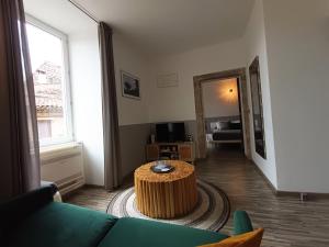 a living room with a couch and a table at Le Mas des Loges - Les Vans / Chambonas in Chambonas