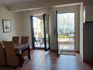 a dining room with a table and a sliding glass door at Studio apartman Monte 2 in Tivat