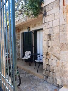 a patio with a table and chairs on a brick wall at Studio apartman Monte 2 in Tivat