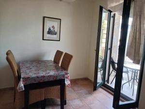 a table and chairs in a room with a balcony at Studio apartman Monte 2 in Tivat