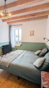 a large bed in a room with a window at Auberge de la Belette Cendrée in Saint-Léger-sous-Beuvray +11 photos