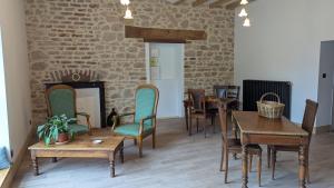 a living room with tables and chairs and a fireplace at Auberge de la Belette Cendrée in Saint-Léger-sous-Beuvray