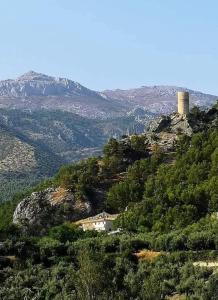 a house on top of a mountain with a tower at Alojamiento Turístico Mirador del Castillo in Bedmar