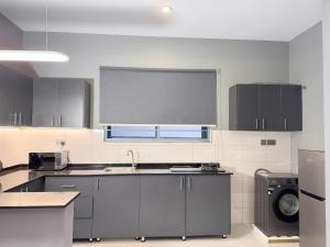 a kitchen with a sink and a washing machine at Mody Haven in Kampala