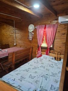 a bedroom with a bed in a wooden cabin at Vikendica Dani in Ljubovija