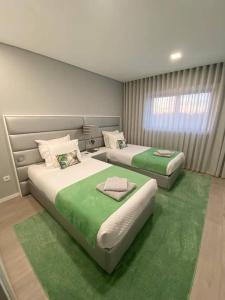- 2 lits dans une chambre avec moquette verte dans l'établissement AgrelaBeach, à Marinhas 6 autres photos