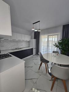 a white kitchen with a table and chairs at Vila Luxury  +3 photos