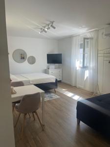 a room with two beds and a table and a tv at BeoAir apartments in Surčin