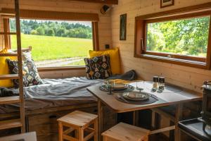 a room with a bed and a table and a window at Ráj pod Troskami in Semily