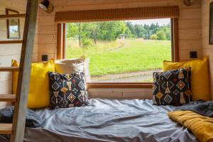 a bed in a tiny house with a window at Ráj pod Troskami in Semily