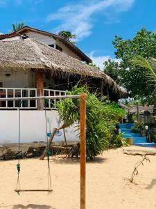 a house on the beach with a swing at Little Pumpkin Cabanas & seafood restaurant in Tangalle
