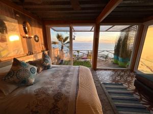 a bedroom with a bed with a view of the ocean at Pacificsunset Reñaca in Viña del Mar