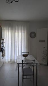 a table and chairs in a room with a window at Domu S'Aratzia - Vicino al mare - con parcheggio privato in Quartu Sant'Elena