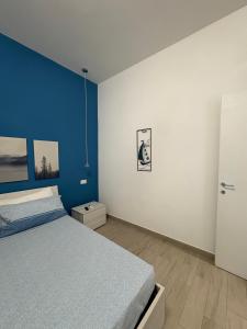 een slaapkamer met een bed en een blauwe muur bij Alloggio Turistico Mare Blu Gaeta in Gaeta