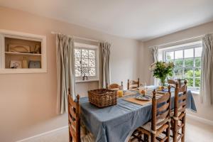 een eetkamer met een blauwe tafel en stoelen bij Postmill Cottage in Burnham Market
