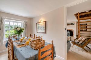 een eetkamer met een tafel en een open haard bij Postmill Cottage in Burnham Market +11 foto's