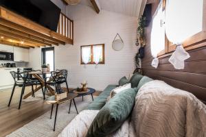 a living room with a couch and a table at L'Écrin - Chalet & Bain Nordique Luxe vue lac in Prouilly