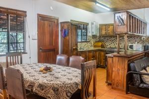 ein Esszimmer mit Tisch und eine Küche in der Unterkunft Owl House Marloth Park in Marloth Park + 11 Fotos