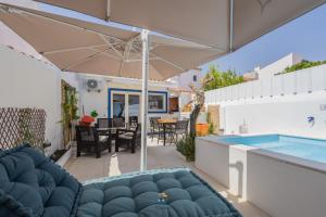 a patio with an umbrella and a swimming pool at Casa da Viajante in Fronteira