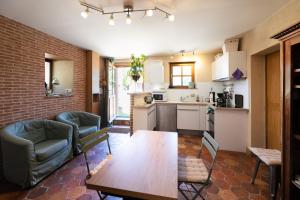 a kitchen and living room with a table and chairs at La Ferme au colombier in NÃ©ron