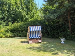 a blue and white chair sitting in the grass at Appartements Am Selliner Hochufer - wenige Gehminuten zum Strand in Ostseebad Sellin +98 photos