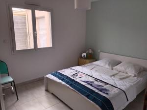 a bedroom with a bed and a window and a chair at Villa Les Arts in Talmont +11 photos