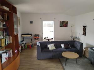 a living room with a blue couch and a table at Villa Les Arts in Talmont