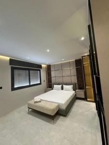 1 dormitorio con cama blanca grande y banco en Studio sky lux 94, en Tánger 1 foto más