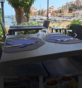 una mesa con platos y utensilios encima en Monolocale La Chicca, en Castellammare del Golfo