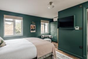 Un dormitorio con una cama grande y un televisor de pantalla plana. en Hermes Hotel by Nestor, en Kingston upon Thames