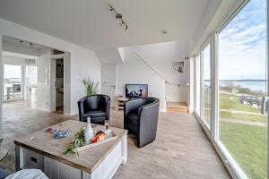 a living room with a table and chairs at Maisonette Fewo Kapteins Lounge by Seeblick Ferien ORO, Rundum Wasser, 6Pers, Sauna, Kamin in Olpenitz