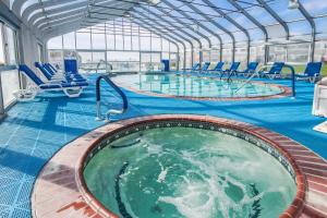 a swimming pool with chairs in a building at Edgewater Beach Resort in Dennis Port +10 photos