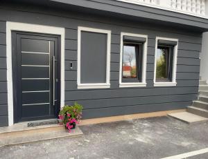 a gray house with a door and two windows at Saray&App in Sarajevo