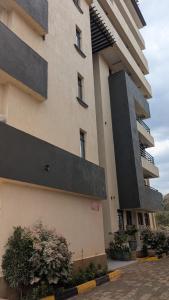 a large building with black detailing on the side of it at Krystal suites in Juja +8 photos