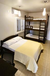 a bedroom with a bed and two bunk beds at Casa no Bosque in Santa Cruz do Sul