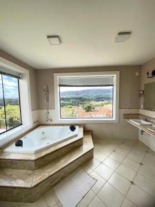 a large bathroom with a large tub and a window at Pousada Varandinha in Tiradentes +101 photos