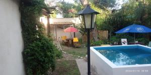 a garden with a pool and a street light and an umbrella at Monoambiente Colibrí in Capilla del Monte