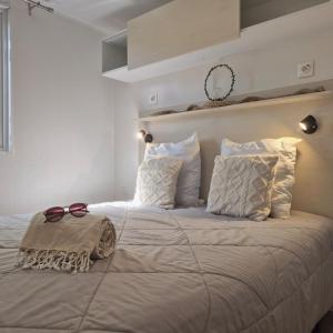 a bedroom with a large bed with two glasses on it at Mobil Home Cosy Plage à 50 m Camping 5 in Torreilles
