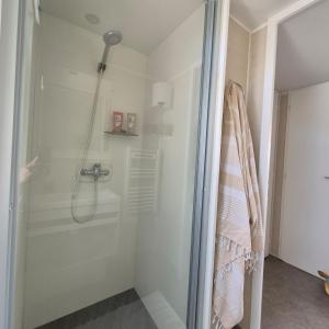 a shower with a glass door in a bathroom at Mobil Home Cosy Plage à 50 m Camping 5 in Torreilles
