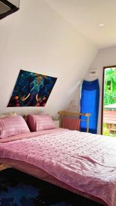 Un dormitorio con una cama con un cuadro en la pared. en Thanya local campsite Thailand, en Ban Thai Thai