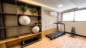 a gym with a treadmill and a television in a room at Áurea Bauten Cabo Branco Genius Flats in João Pessoa