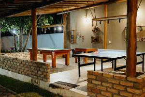 a patio with ping pong tables and a brick wall at Chalé Buriti – Vila das Carnaúbas | 1 chalé in Barreirinhas