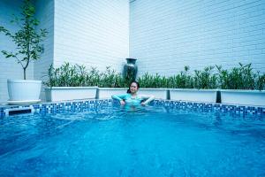 a woman is sitting in a swimming pool at Amshiga 1 in Jimbaran