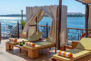 a deck with two chairs and a table on the water at Sonesta Dahabeya Amirat I - Nile Cruise Ship From Luxor to Aswan 7 nights in Luxor +22 photos