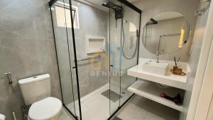 a bathroom with a shower and a toilet and a sink at Áurea Bauten Cabo Branco Genius Flats in João Pessoa