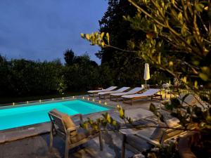 a swimming pool with chaise lounge chairs and a swimming pool at La Meslaysienne - Comfortable house, swimming pool in Meslay-le-Vidame