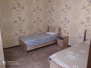 a small bedroom with a bed and flowers on the wall at Humo Hotel and Restaurant in Bŭston +14 photos